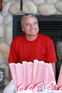 A happy guest in front of bags of popcorn