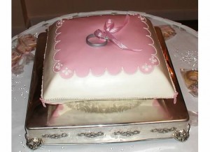The cake to look like a ring bearers pillow with two rings