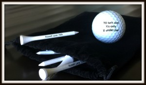 3. Sleeve of golf balls and tees, reading "70 isn't bad;, it's 2 under par"